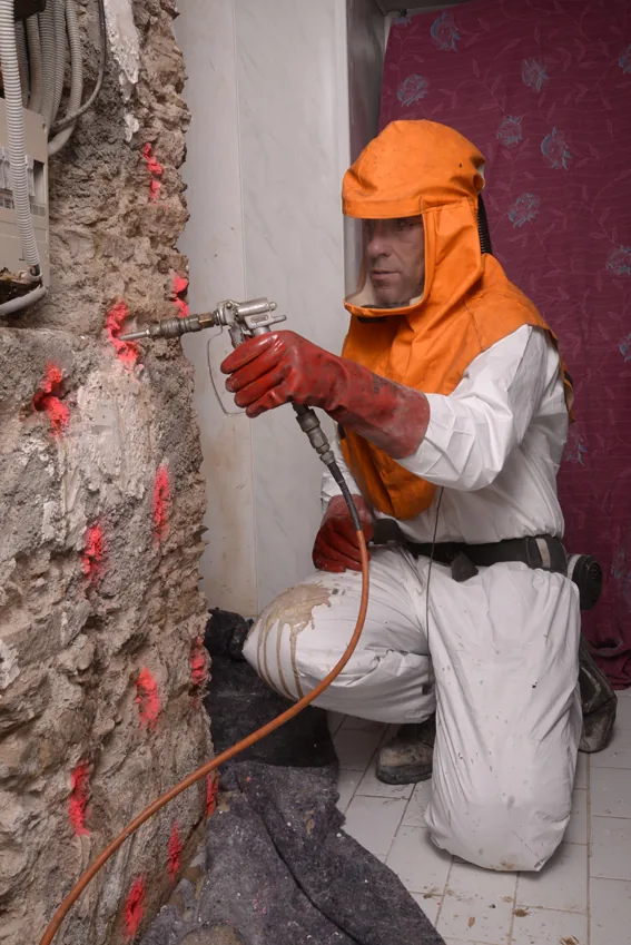 Technicien O.C.P.C réalisant une injection dans un mur